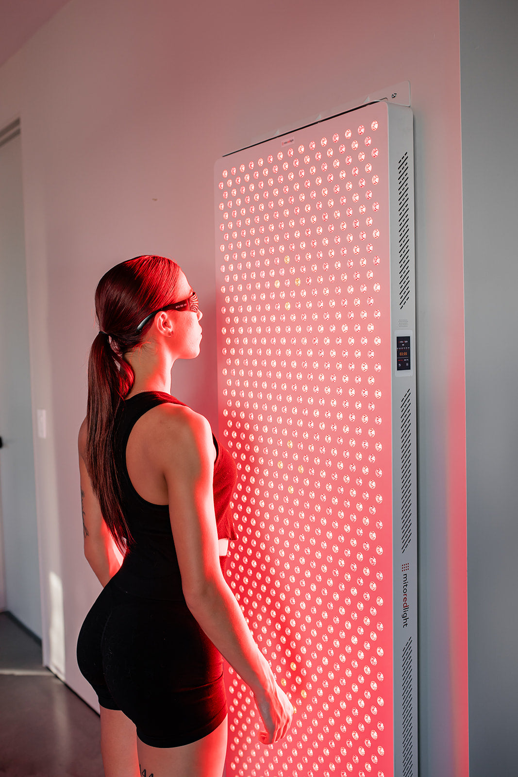 MitoPRO Commercial Ultimate X | Model standing infront of wall mounted red light panel